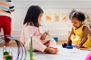 Three young children in a playroom